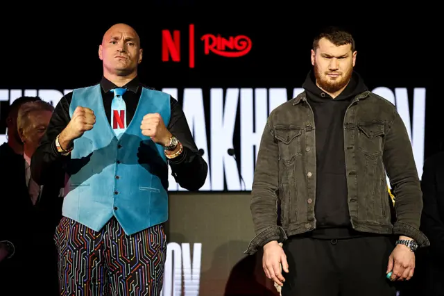 Tyson Fury holds up his fists and stands next to Arslanbek Makhmudov