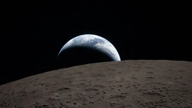 The Earth is viewable beyond the Moon from the Orion spacecraft window during the Artemis II mission. A crescent on the top portion of the Earth is visible while the rest of the planet is in darkness, with the Moon in the foreground of the image.