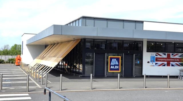 An Aldi store near the bomb site is protected from the explosion with wood sheeting