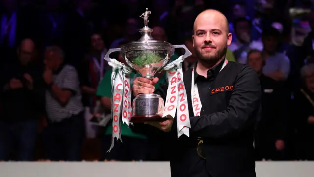 Luca Brecel holds the World Championship trophy