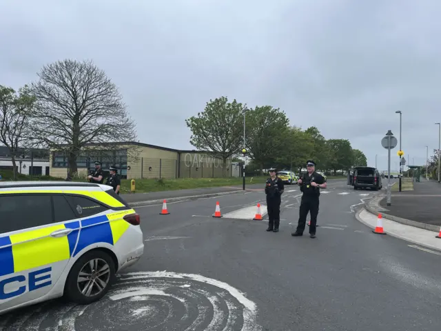 Police officers stood in the road.