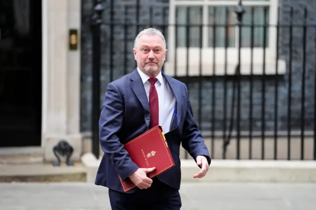 Housing Secretary Steve Reed leaves following a Cabinet meeting in Downing Street, wearing a suit and carrying a red folder.