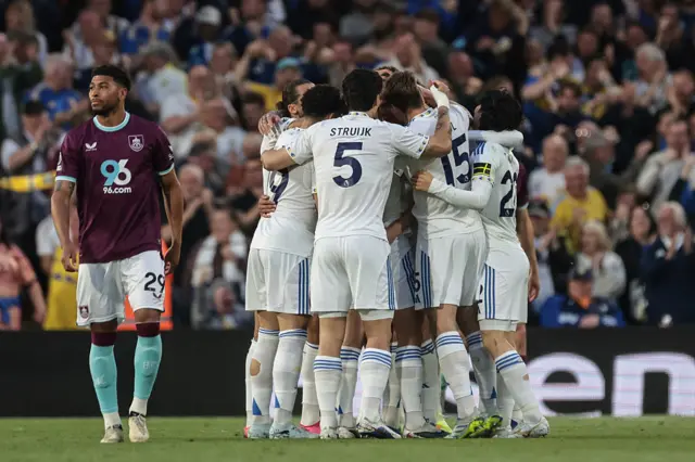 Leeds players celebrate as Burnley trudge back to kick off