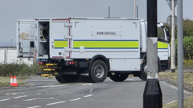A bomb disposal van in the middle of a road.