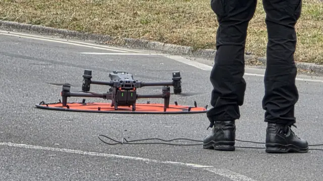 A black drone on the ground.