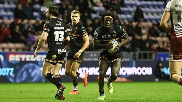 Eribe Doro runs past the Wigan defense during the Super League
