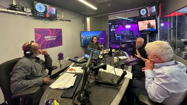 Four people sitting at a desk in the Radio London studio