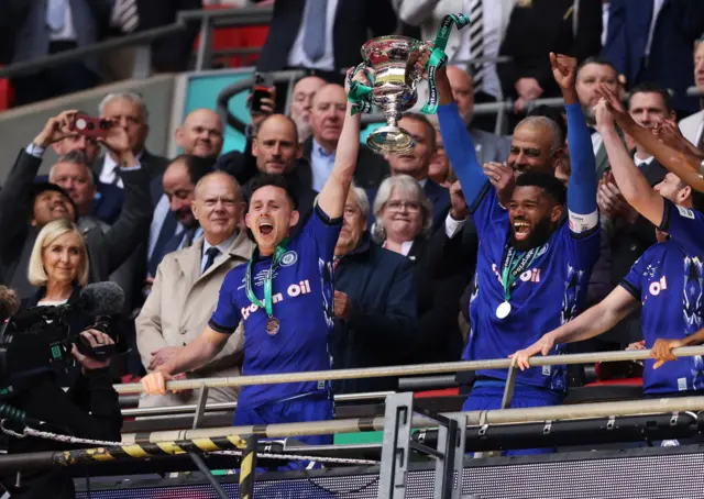 Ian Henderson and Ethan Ebanks-Landell of Rochdale celebrates with the play off trophy