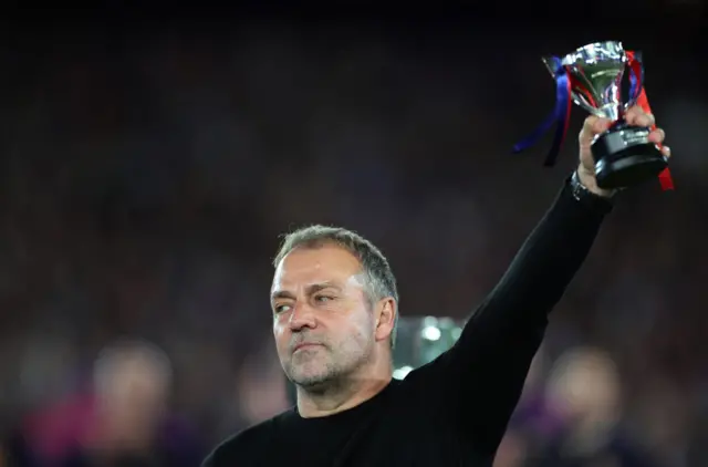 FC Barcelona coach Hansi Flick celebrates with a trophy