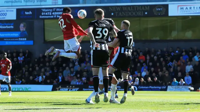 Adebola Oluwo scores with a header for Salford