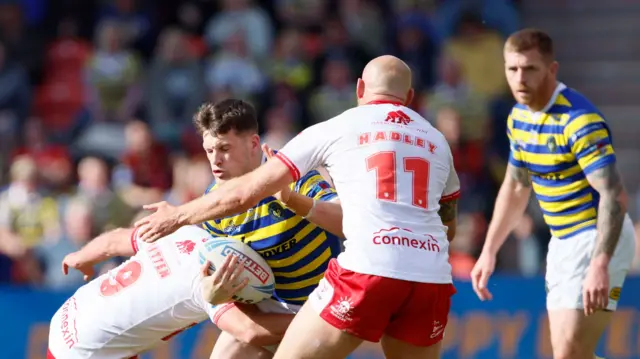 Warrington Wolves' Josh Thewlis is tackled by Hull KR's Karl Lawton and  Dean Hadley