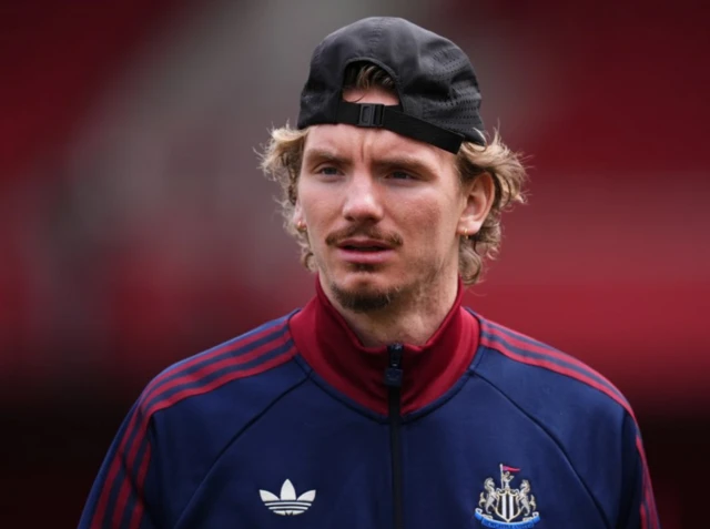 Nick Woltemeade wearing a baseball cap and a Newcastle branded jacket