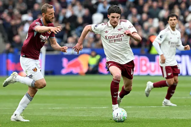 Declan Rice of Arsenal runs with the ball while under pressure from Tomas Soucek of West Ham United