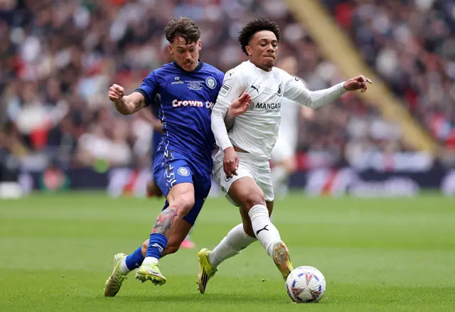 Leon Ayinde of Boreham Wood battles for possession with Luke Hannant of Rochdale