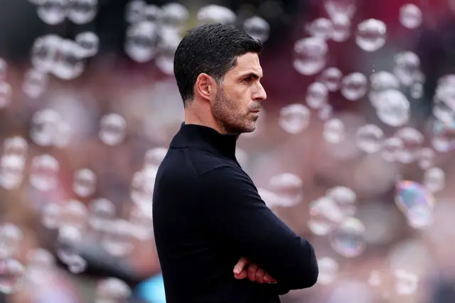 Arteta stands arms crossed surrounded by bubbles