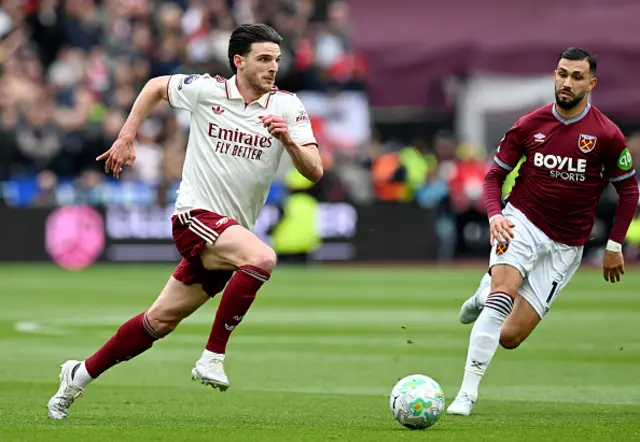 Declan Rice of Arsenal runs with the ball while under pressure from Taty Castellanos