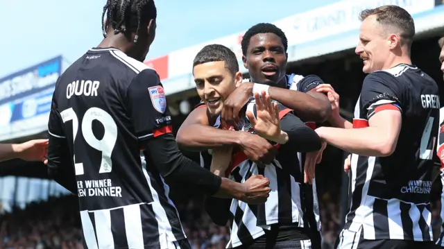 Jaze Kabia of Grimsby Town celebrates scoring the opening goal against Swindon from a penalty with team mates