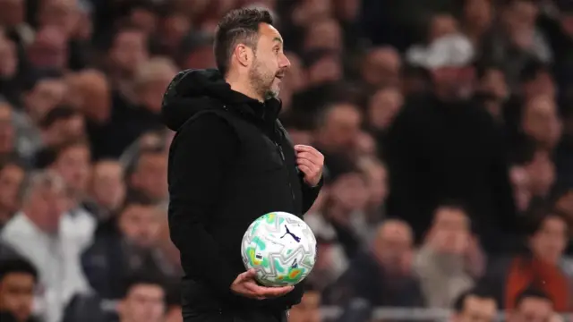 De Zerbi holds the ball and points at himself