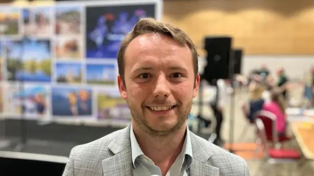Headshot of Chris Curtis who gives a smile looking into the camera