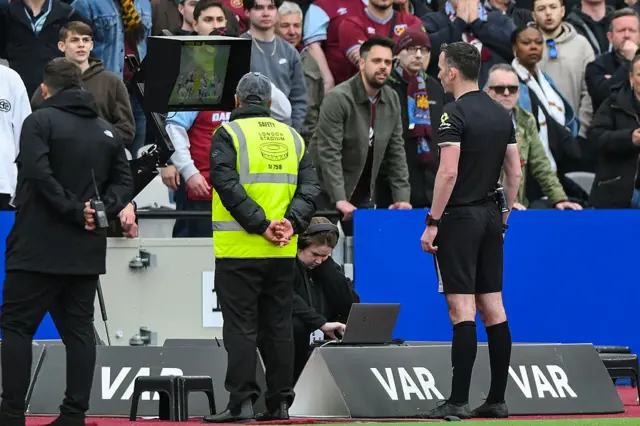 Referee Chris Kavanagh looks at the monitor in the London Stadium
