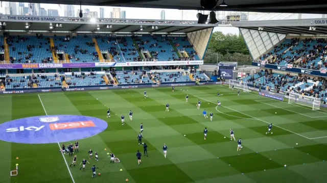 Players warming up at The Den