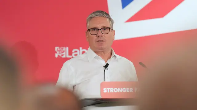 Starmer stood behind a podium.
