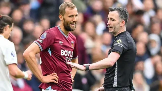 Tomas Soucek of West Ham United speaks with match referee Chris Kavanagh