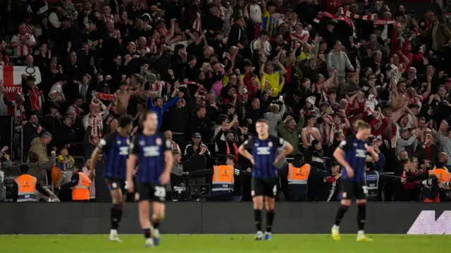 Southampton fans celebrate as Middlesbrough players have their hands on their hips