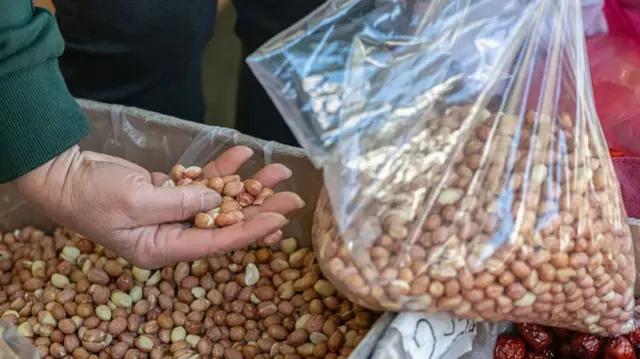A shopper sifts through a box of soybeans in the Chinatown neighborhood of San Francisco
