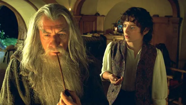 A film still from the Lord of the Rings shows Gandalf smoking his pipe with Frodo to his right