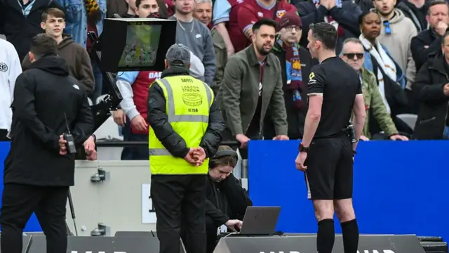 Match referee Chris Kavanagh reviews a VAR decision on a West Ham goal during the Premier League match between West Ham United and Arsenal