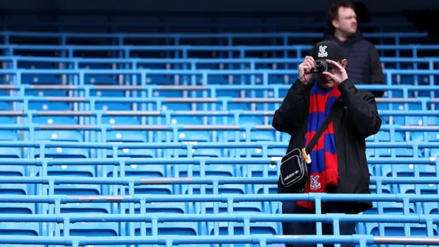 A fan of Crystal Palace takes photos inside the stadium