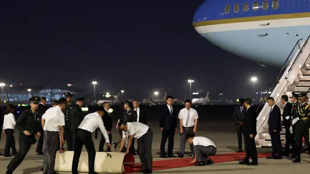 Staff members prepare a red carpet as U.S. President Donald Trump arrives on Air Force One at Beijing Capital International Airport on May 13, 2026 in Beijing, China