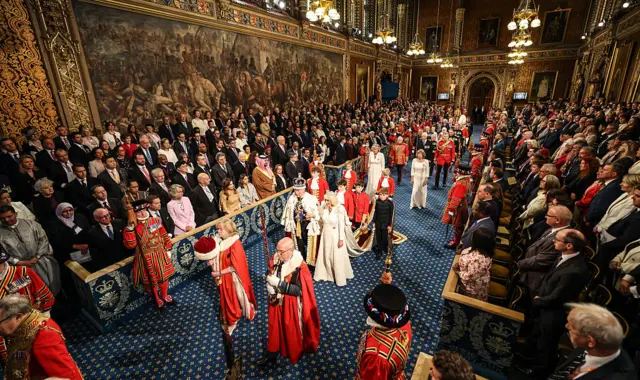 King Charles III and Queen Camilla process into the Lord's chamber through the royal gallery during the state opening of Parliament