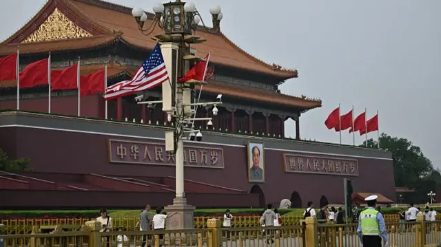 The national flags of the United States and China hang in front of the portrait of late communist leader Mao Zedong at Tiananmen Gate on May 13, 2026.