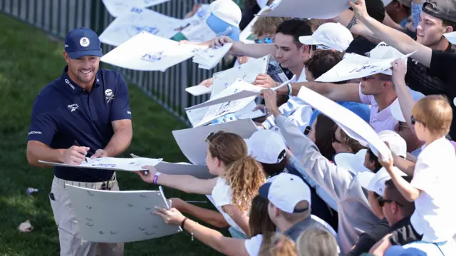 Bryson DeChambeau signs autographs for fans