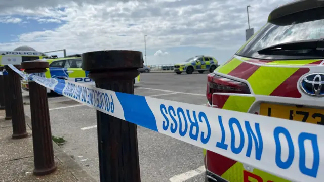 Close-up image of police tape behind a police car