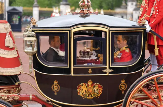 Karroca shtetërore e Mbretëreshës Alexandra, që mbante Kurorën Perandorake Shtetërore dhe Shpatën e Shtetit, niset nga Pallati Buckingham në Londër, përpara Hapjes Shtetërore të Parlamentit në Dhomën e Lordëve në Pallatin e Westminster në Londër.