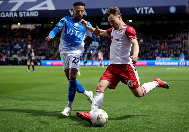 Dan Kemp of Stevenage runs with the ball while under pressure from Odin Bailey