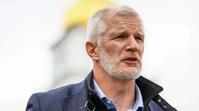 Al Carns in a blue coat