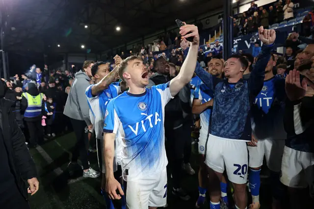 Ben Osborn of Stockport County celebrates with team mates after the team's victory