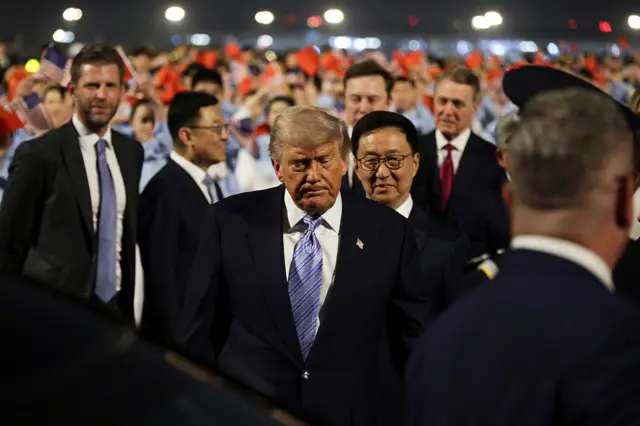 Trump walks with Eric Trump and Elon Musk in the background