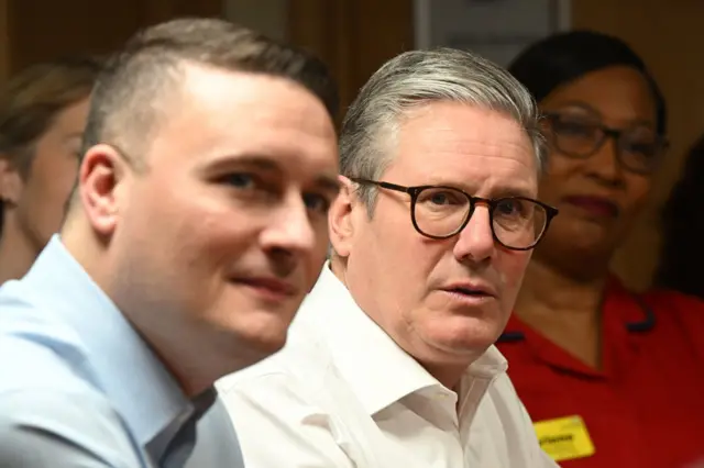 Wes Streeting sits next to Keir Starmer during a visit to a healthcare provider in Surrey