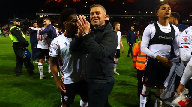 Bolton boss Steven Schumacher claps the travelling support