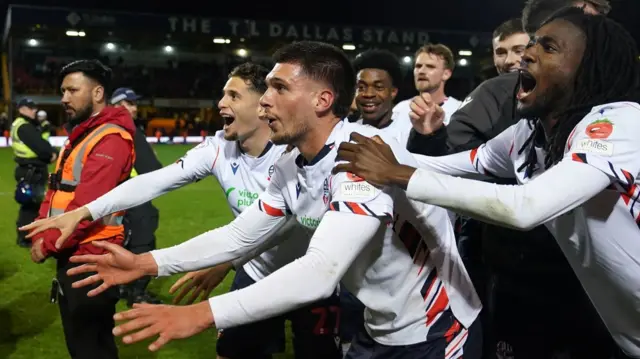 Bolton players celebrate in front of their fans