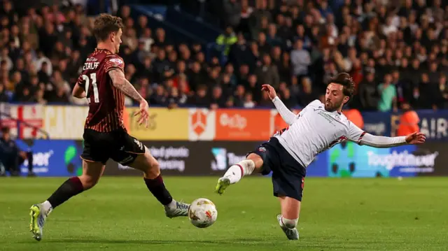 Josh Sheehan slides in to tackle Bradford's Jenson Metcalfe