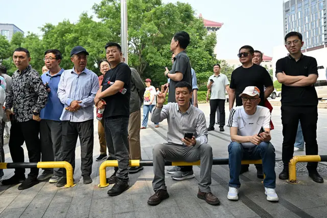People gather to watch the pass of the motorcade of US President Donald Trump in Beijing