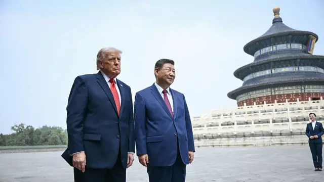 Trump and Xi pose for a photo in front of a circular building