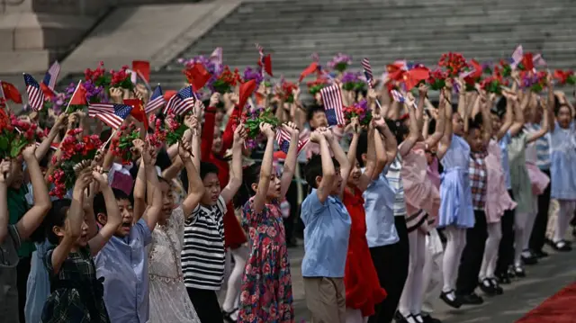 Children waving flags and flowers