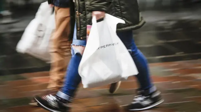 An image of two people carrying shopping bags.
